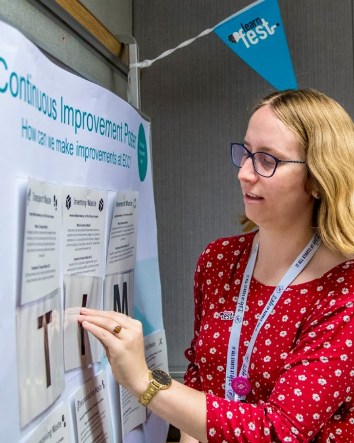 Woman placing the letter I onto a board to spell TIM