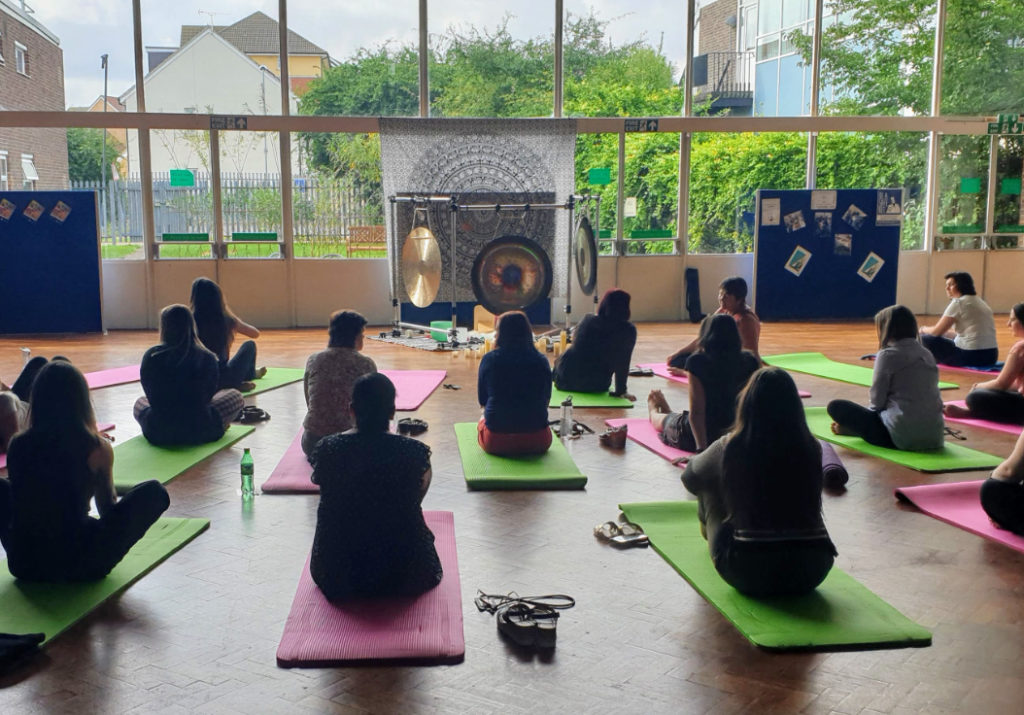 A group of people sitting on Yoga mats at a wellbeing event